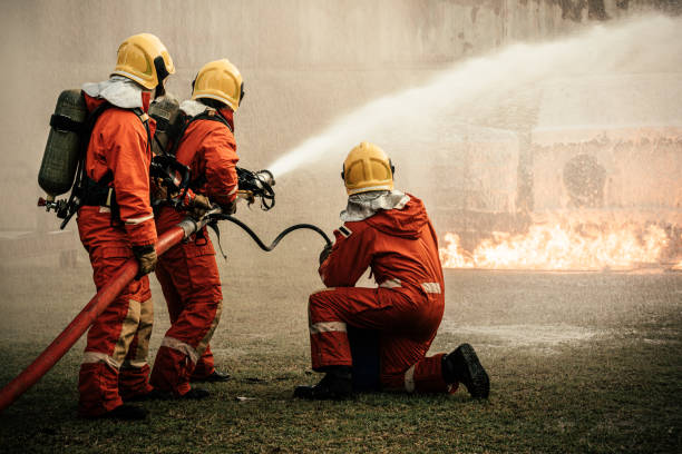 Firefighters using fire hose extinguishing burning fire